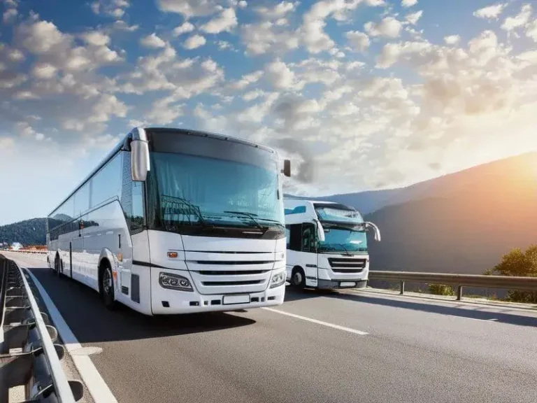 White bus and truck crossing a highway bridge, showcasing two types of road transport