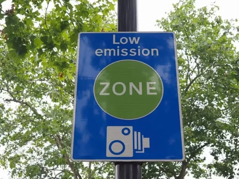 A sign on a pole indicating a Low Emission Zone, restricting high-emission vehicles from entering